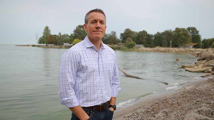 Jason Huntley, Ph.D., standing on a beach